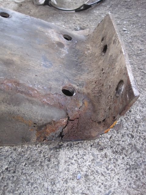 1989 Ford Bronco - A heavily rusted metal bracket, likely a vehicle part, shows significant corrosion and damage.
