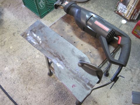 1989 Ford Bronco - A Craftsman reciprocating saw is positioned over a metal piece that is clamped to a stool.