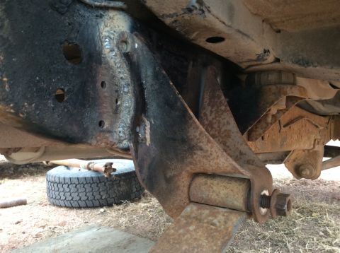 1979 Ford Bronco - Close-up view of a modified rear suspension shackle flip, showing the leaf spring and U-bolt assembly.