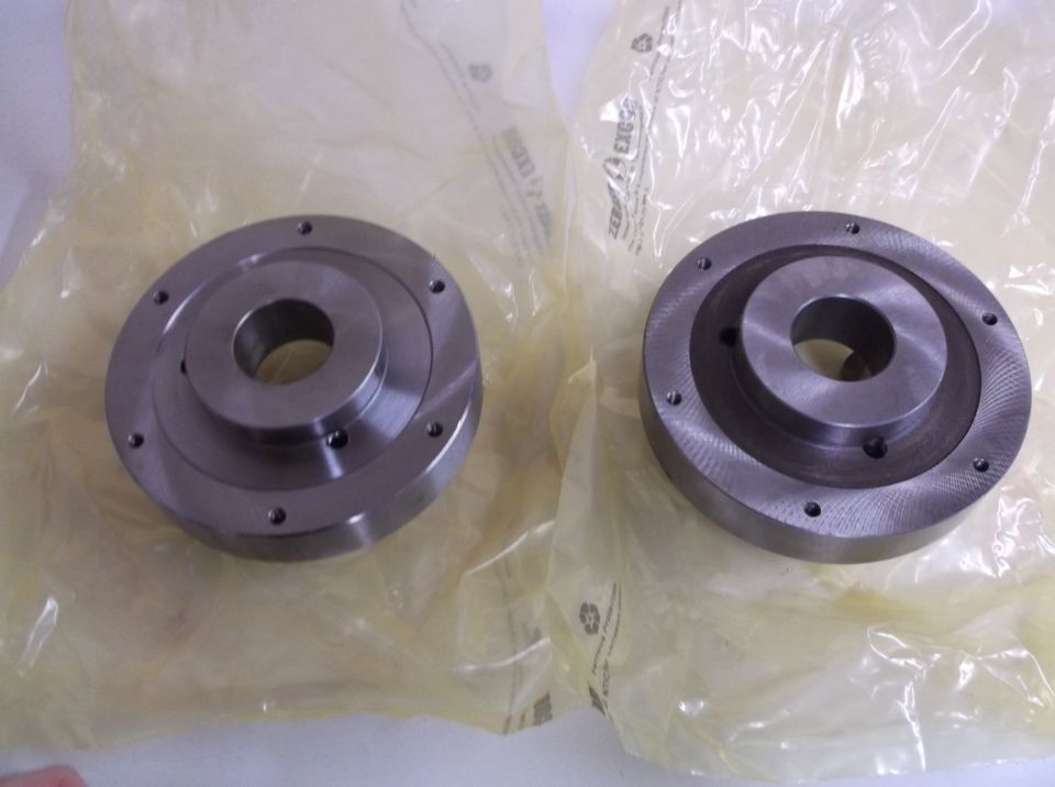 two round metal parts, possibly brake rotors or hubs, in plastic packaging