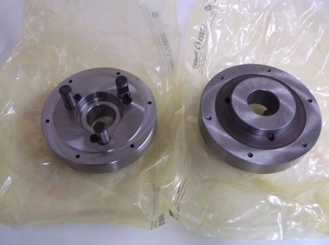 1995 Mercury Grand Marquis - Two metal machine parts are shown, each wrapped in protective plastic packaging.