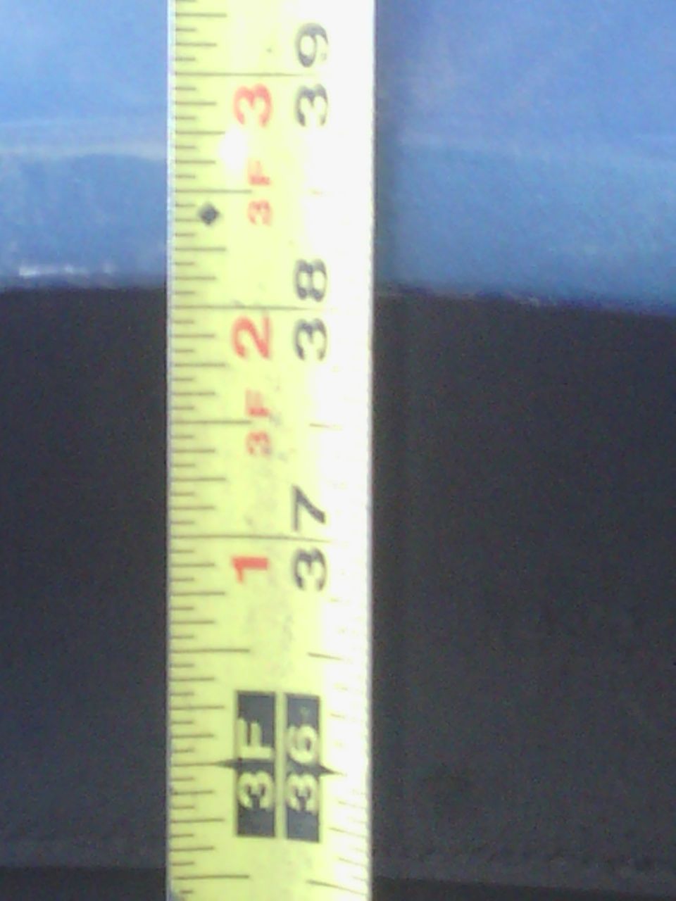 Yellow tape measure showing measurements from 36 to 39 inches against a dark background