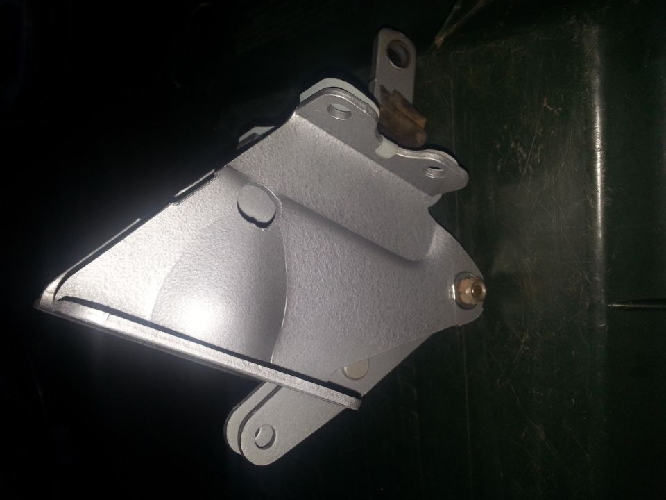 Silver metal bracket with bolt and pivot points, against a dark background