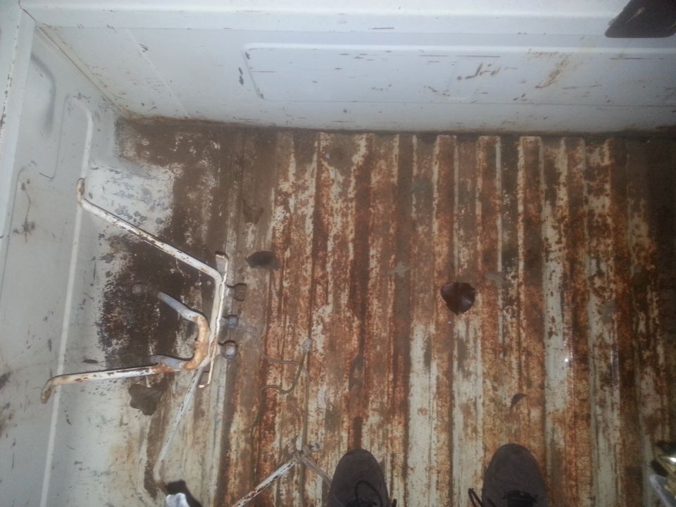 Rusted truck bed interior with tie-down hooks and visible Supermotors.net watermark