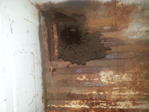 1973 Ford F-100 - Severe rust and damage visible in the truck bed, indicating significant deterioration.