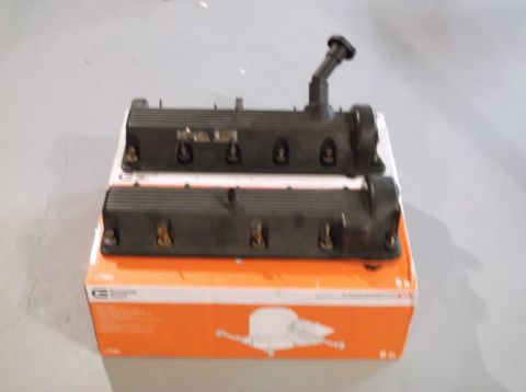 1995 Mercury Grand Marquis - Engine valve covers are shown stacked on a box, with a black hose fitting on one.