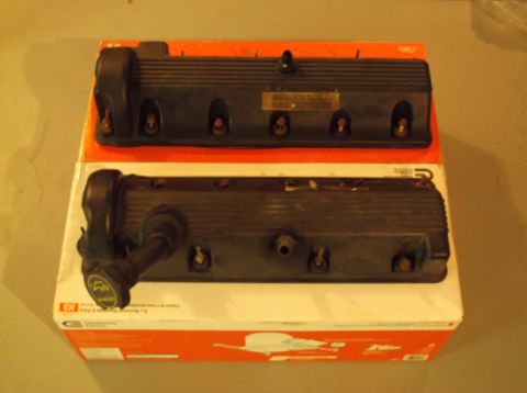 1995 Mercury Grand Marquis - Two engine valve covers are shown, one with a hose and connector, resting on a box.