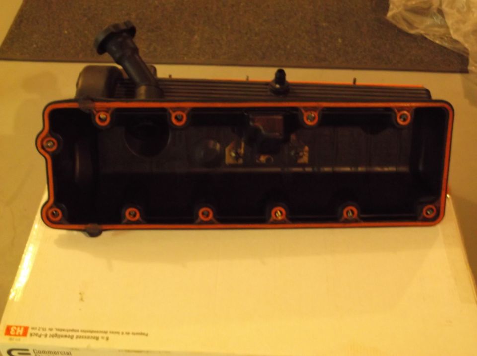 Engine valve cover with orange gasket and black cap