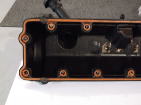 1995 Mercury Grand Marquis - A close-up view of an engine valve cover gasket, revealing its orange seal and internal mechanical parts.
