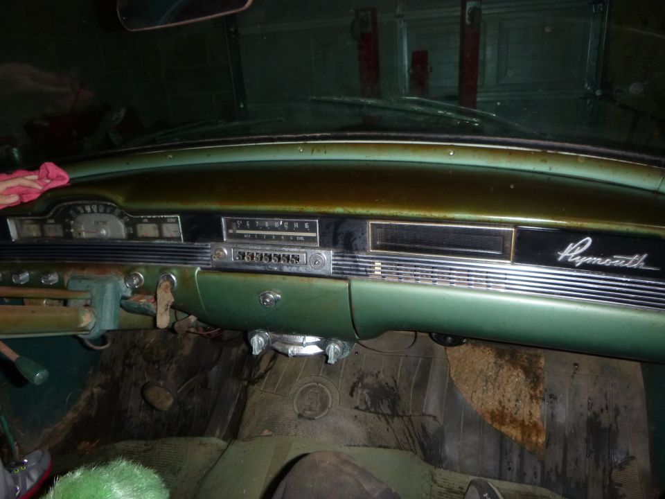 Green dashboard of a 1953 Plymouth Belvedere with a radio and gauges