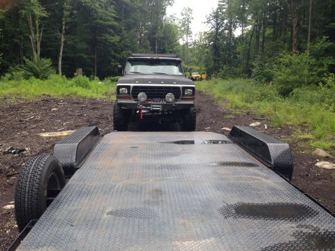 1979 Ford Bronco - Ford Bronco on a dirt road with a trailer in front and another vehicle behind.