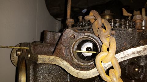 1995 Ford Bronco - Rusty engine part with a chain. Year and vehicle unknown.