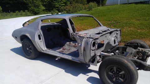 1970 Pontiac Trans Am - Primer gray 1970 Pontiac Trans Am body shell sits on a concrete surface, ready for restoration.