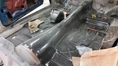 1970 Pontiac Trans Am - The interior floor of a car is shown during a restoration project, with tools and a welding mask present.