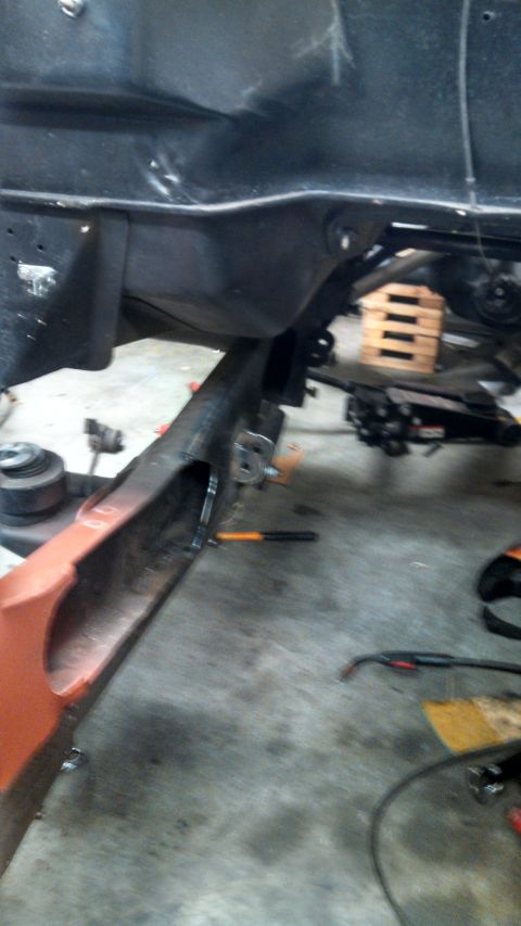 1967 Ford F-250 - Close-up view of a truck frame and an orange fender, showing recent welding work.