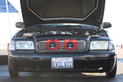 2003 Ford Crown Victoria - Front view of a black sedan with hood raised, twin red air filters behind the grille and a California EVIL VIC plate.