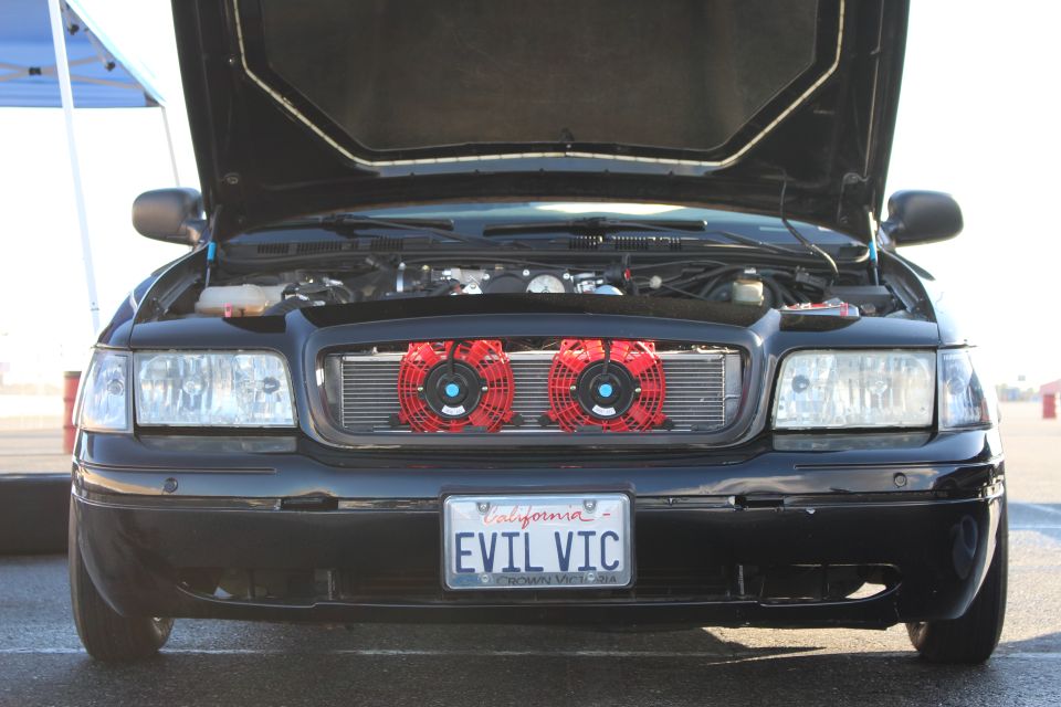 Front of black sedan with open hood, dual red air filters and EVIL VIC plate