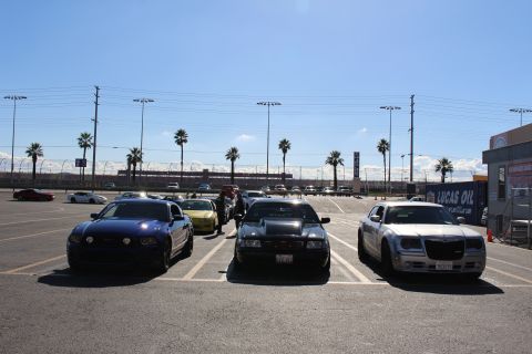 2003 Ford Crown Victoria - blue coupe, black sedan, and silver Chrysler 300 parked facing forward near a Lucas Oil sign at a sunny dragstrip.