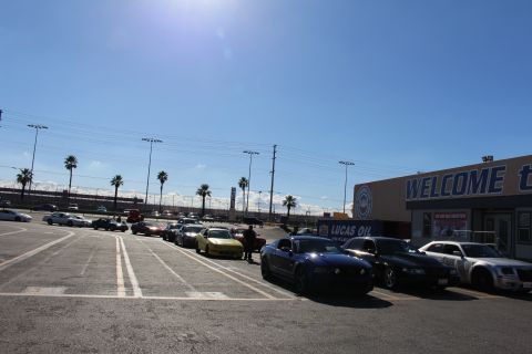 2003 Ford Crown Victoria - Cars including a blue coupe and silver sedan line a sunny parking lot beside a WELCOME building and Lucas Oil signage.