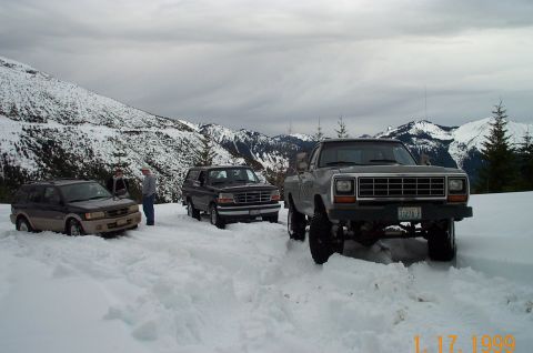 1995 Ford Bronco - Three SUVs and trucks are stuck in deep snow in a mountainous area.