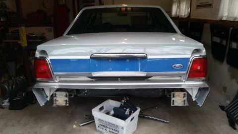 1991 Ford LTD Crown Victoria - Rear view of a white and blue Ford Crown Victoria with its bumper removed, parked indoors.