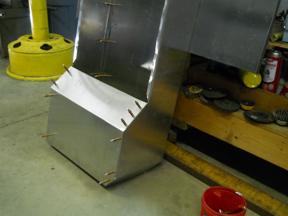Metal fabrication project with visible rivets and unfinished edges