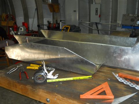 1992 Ford Bronco - Metal parts are laid out on a workbench with various tools for fabrication.