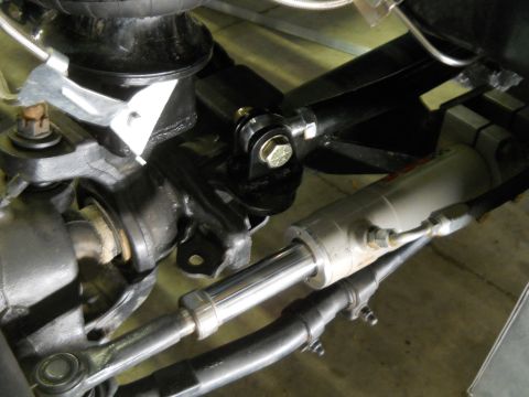 1992 Ford Bronco - A close-up view of the suspension and steering components of a vehicle, featuring a hydraulic steering cylinder, tie rods, and an air sprin…