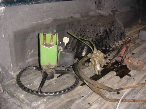 1992 Ford Bronco - Steering wheel and hydraulic parts are stored in the bed of a truck.
