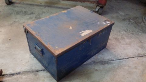 1995 Ford Bronco - A blue metal toolbox with rust on the edges sits on a concrete floor.