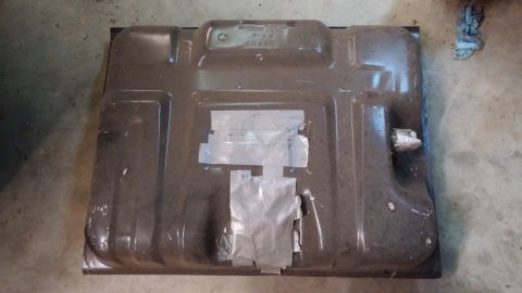 1995 Ford Bronco - The underside of a dark-colored fuel tank is shown, likely from a 1995 Ford Bronco. The tank has several areas covered with silver tape, an…