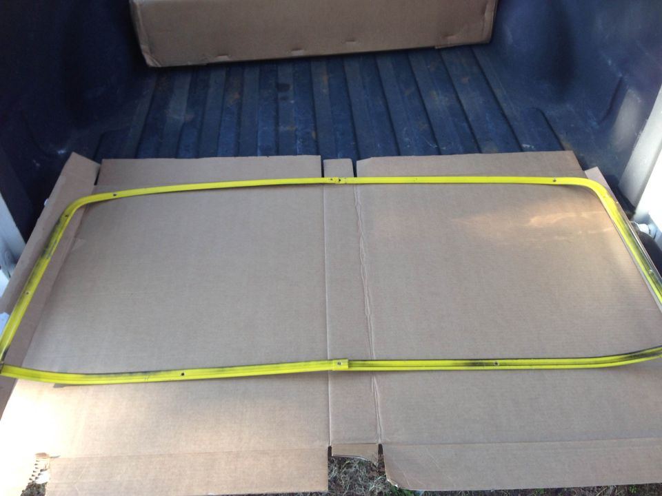 Yellow metal trim piece on cardboard in truck bed