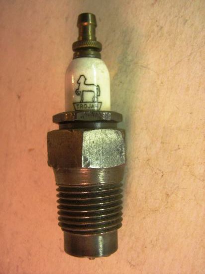 1915 Ford Model T - A close-up view of a vintage spark plug with a distinctive horse logo and brand name.
