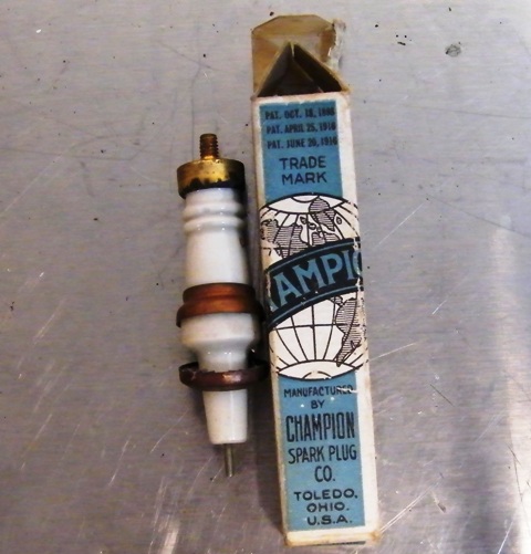 1915 Ford Model T - A vintage Champion spark plug sits beside its original packaging, which lists patent dates from 1914.