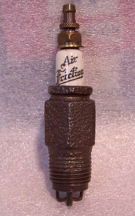1915 Ford Model T - A close-up, straight-on view of a vintage spark plug with white ceramic insulation. The words "Air Friction" are clearly visible in black s…