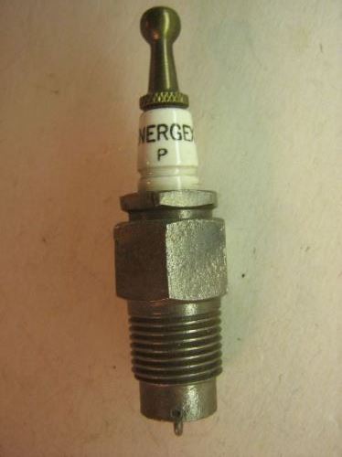 1915 Ford Model T - A close-up, vertical shot of a spark plug with the text "NERGE P" visible on its white ceramic insulator. The spark plug has a metallic hex…