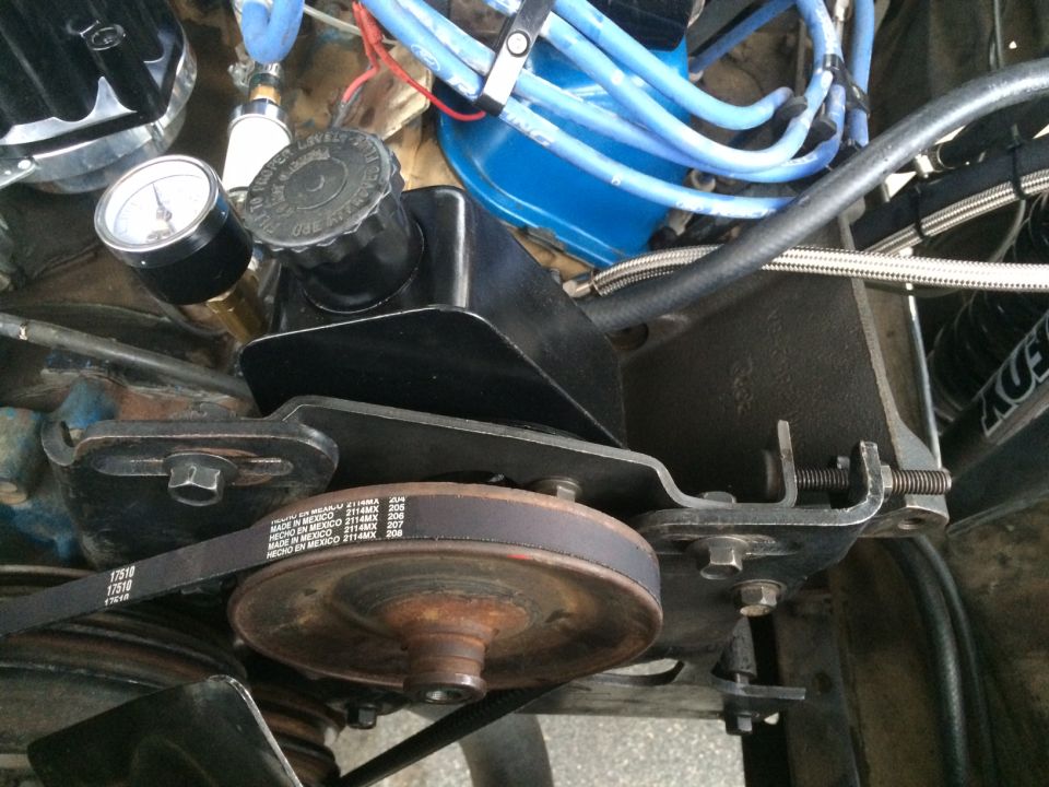Close-up of 1977 Ford F-350 engine bay with power steering pump, belt, and gauge.
