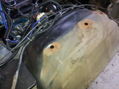 1976 Ford Ranchero - A close-up view of the inner fender well of a vehicle, showing rust and some wiring. The fender well appears to be made of metal and has tw…