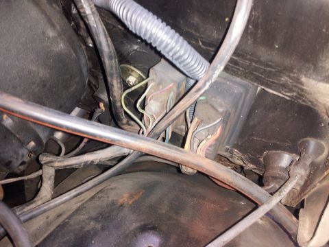 1976 Ford Ranchero - A close-up view of a vehicle's engine bay shows wiring harnesses connected to electrical components. A large metal pipe runs horizontally a…