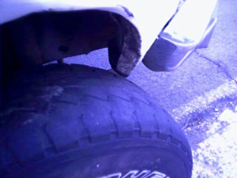 1981 Ford Bronco - A close-up view of a vehicle's tire and fender, with visible rust and wear on the wheel well.