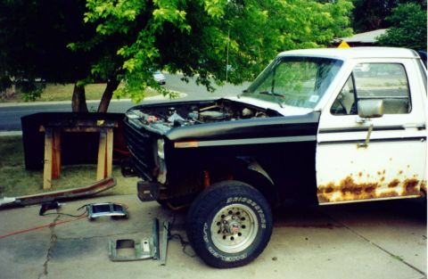 1981 Ford Bronco - Ford pickup truck undergoing repairs with various parts laid out on the driveway.