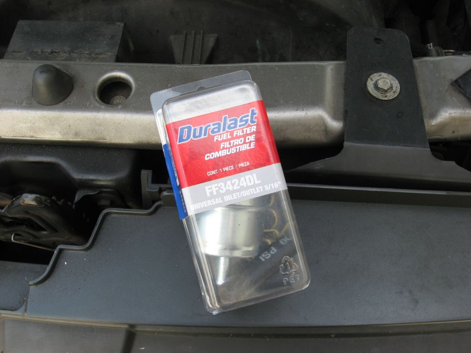 Duralast FF3424DL fuel filter in packaging on a vehicle part.