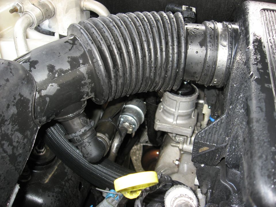 1994 Ford Bronco engine bay with focus on intake hose and engine components.