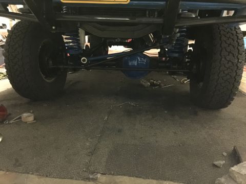 1974 Ford Bronco - Undercarriage view of a modified 1974 Ford Bronco, showing the front suspension, steering components, and differential. The vehicle feature…
