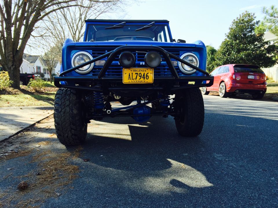 Blue 1974 Ford Bronco front view with bull bar and yellow license plate.