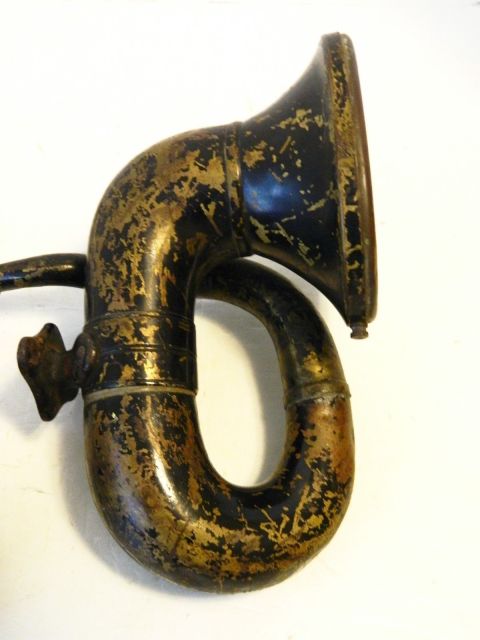 1915 Ford Model T - This is a close-up of an antique, black and gold horn, likely an accessory for a vintage vehicle. The horn has a curved shape with a flared…
