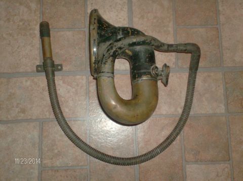 1915 Ford Model T - This is a close-up view of an old phonograph horn and flexible hose, likely a part from a vintage vehicle or accessory. The horn is a dark…
