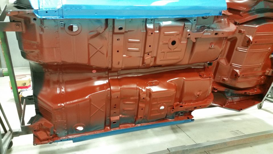 Undercarriage of a car being painted red and blue