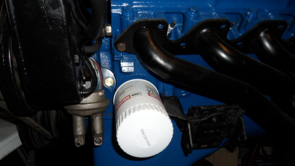 Motorcraft oil filter and fuel pump mounted on a blue engine block with black exhaust manifolds