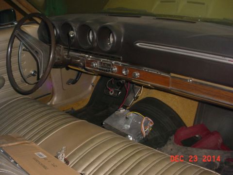 1971 Ford Ranchero - The interior of a classic car shows a bench seat, steering wheel, and dashboard with a wood-grain trim panel.
